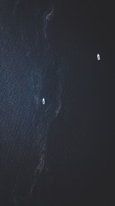 白天水面上两艘白色小船的俯视照片